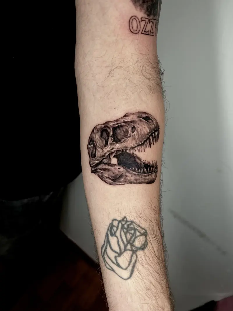 Cráneo de dinosaurio en estilo realista, tatuaje blackwork.