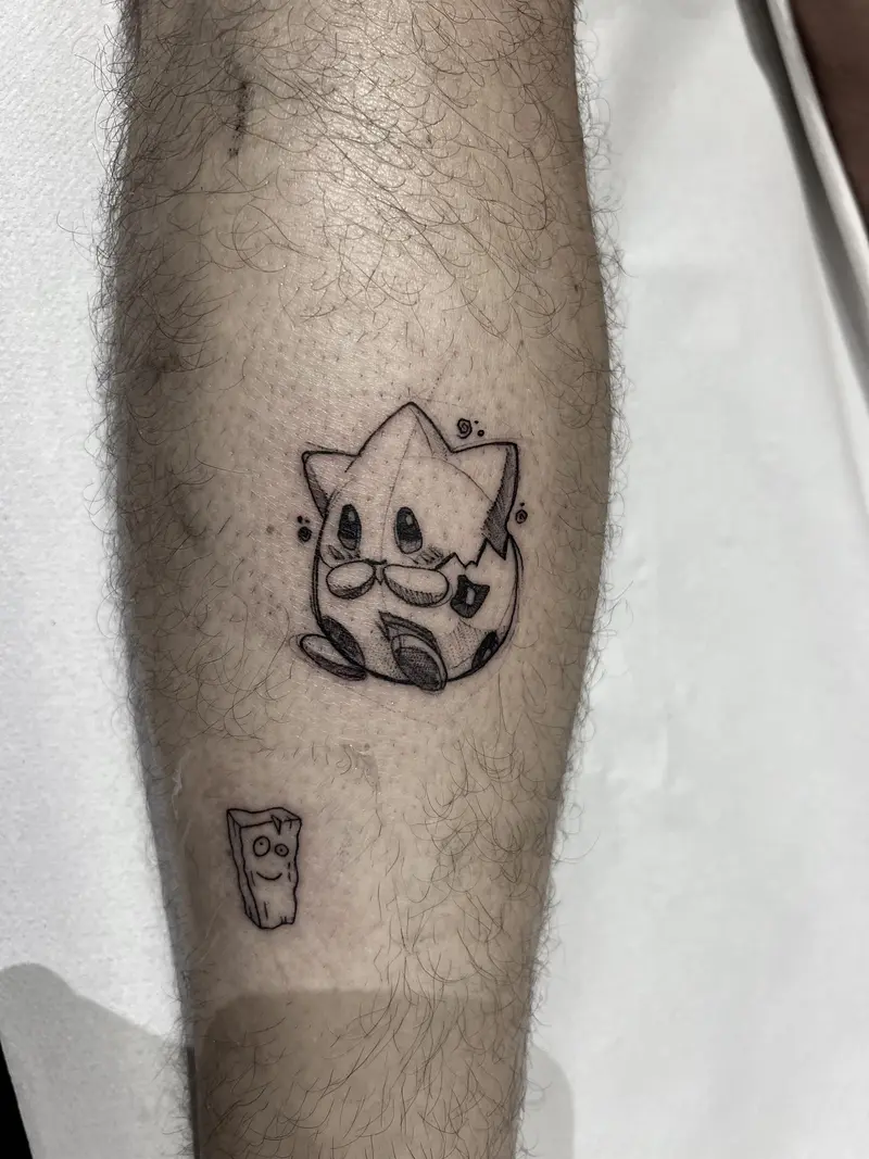 Personaje estilo Pokémon Togepi en tatuaje pequeño, blackwork.