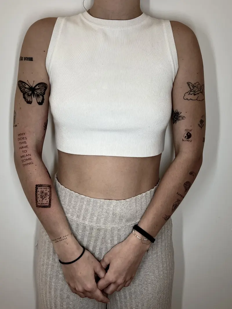 Conjunto de tatuajes pequeños: mariposas, texto y símbolos en ambos brazos.