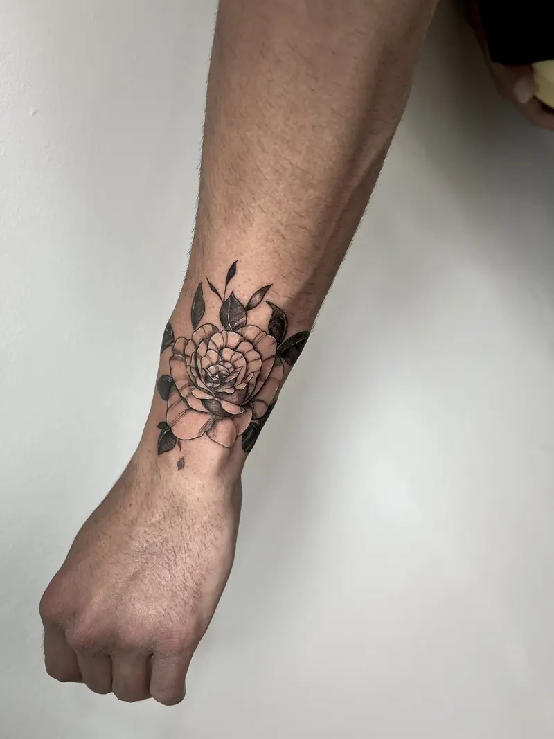 Flor grande tipo peonía con hojas en la pierna, blackwork.