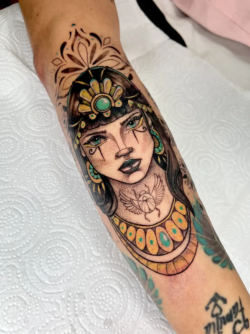 Retrato a color inspirado en Cleopatra con detalles turquesa en antebrazo.