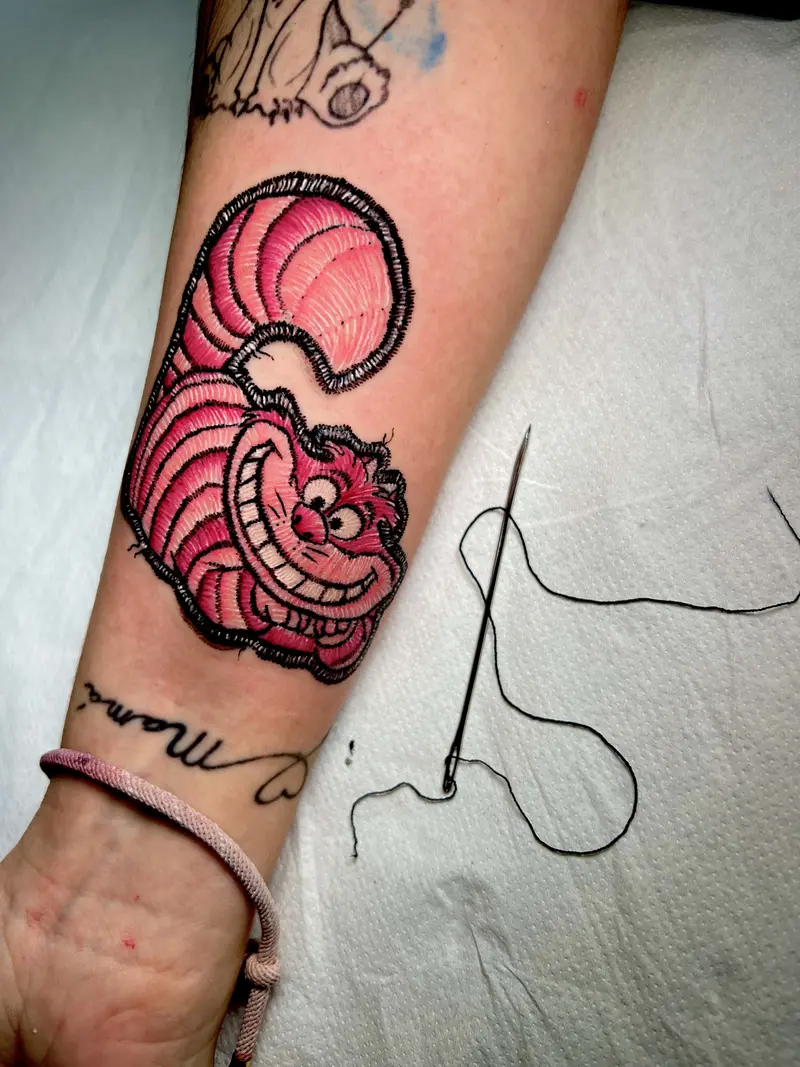 Tatuaje a color del Gato de Cheshire sonriendo, estilo cartoon.
