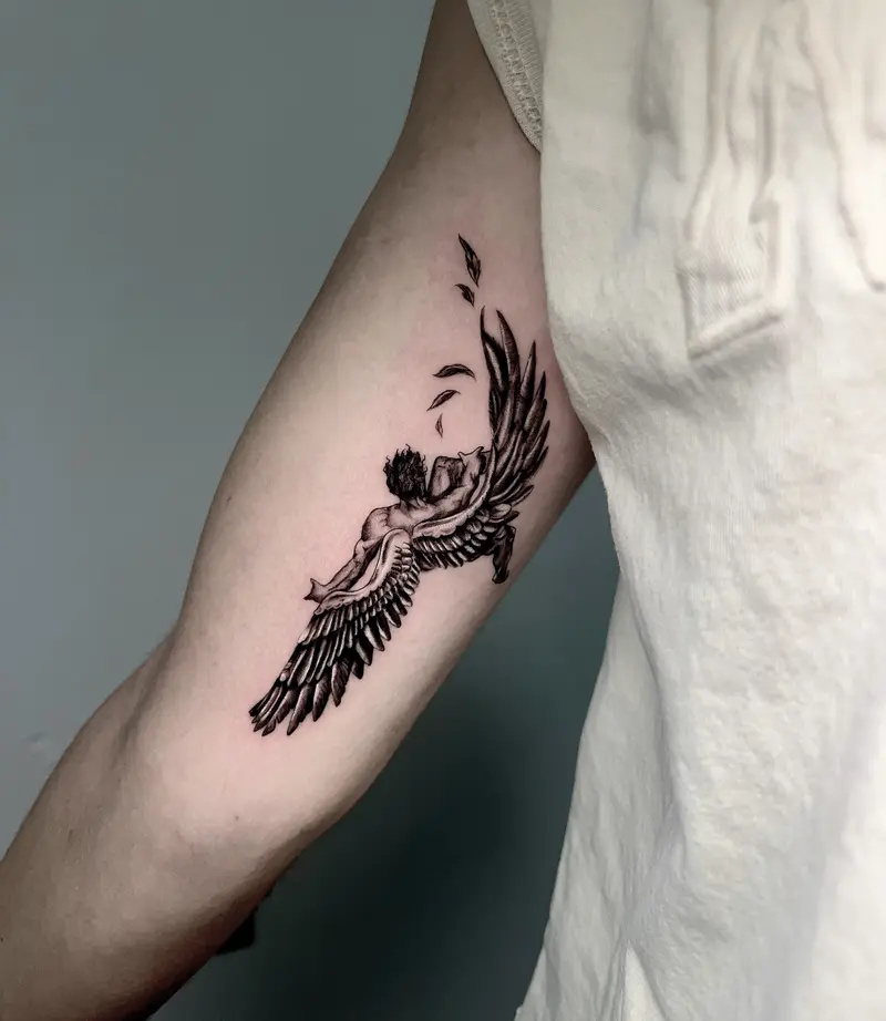 Tatuaje en negro de un ángel o figura alada en movimiento, con estilo gráfico y alto contraste.